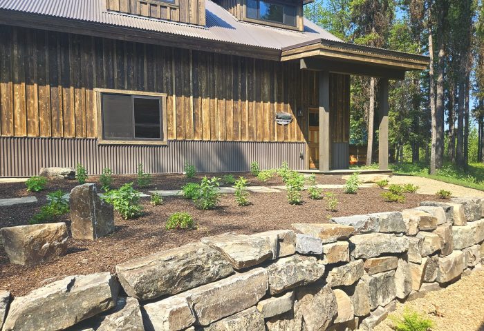 Newly planted garden bed alongside a stone retaining wall, landscape design by Beargrass Landscape Architecture
