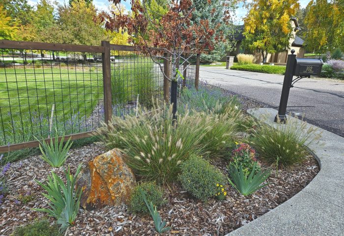 Fence and planted garden bed adjacent to the pergola patio, Bigfork residential project by Beargrass Landscape Architecture