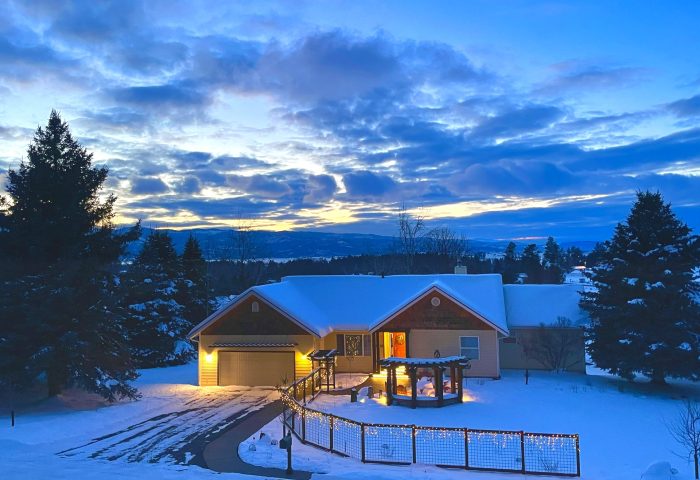 Winter evening view of the finished pergola patio and landscape lighting, Bigfork residential project by Beargrass Landscape Architecture