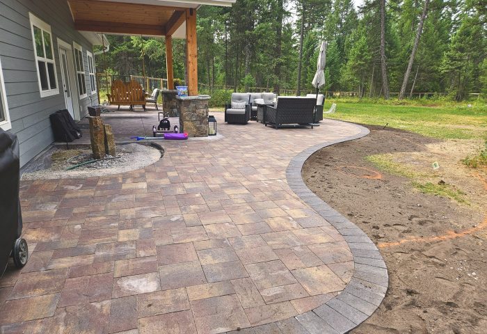 Curved paver patio in a covered space beneath an upper deck, residential landscape design by Beargrass Landscape Architecture