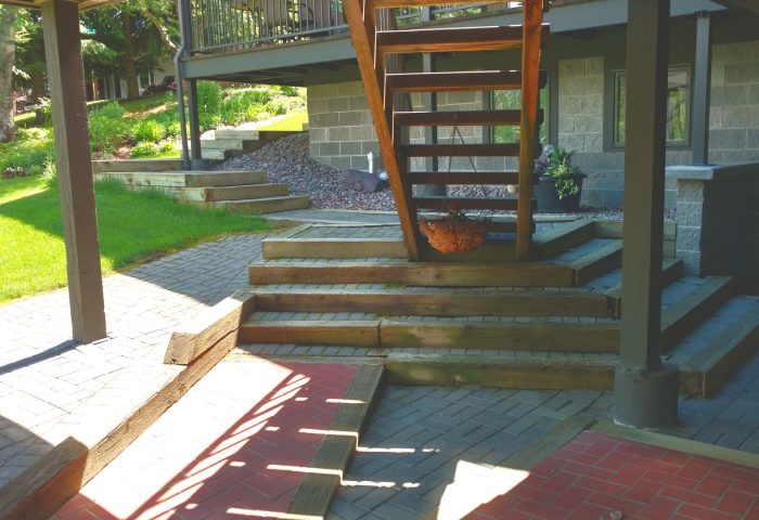Wooden staircase leading down to a stone patio, Whitfish Lake shoreline project by Beargrass Landscape Architecture